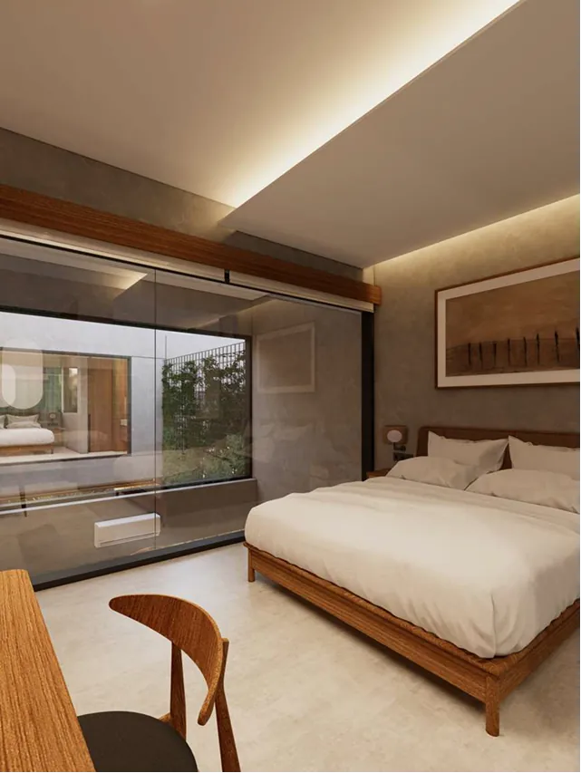 Nusakha Villas bedroom — sunlit bedroom with warm textures, lush outdoor views and a garden-pool outlook through full-height glass